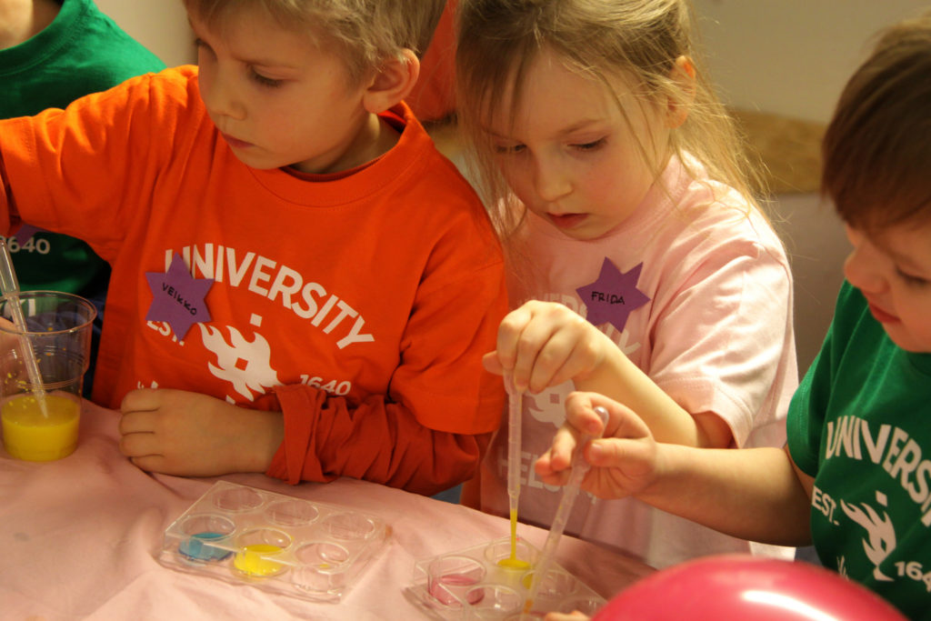Children attending science club and pipetting.