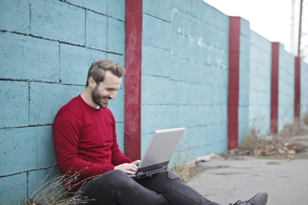en man sitter utomhus vid en dator