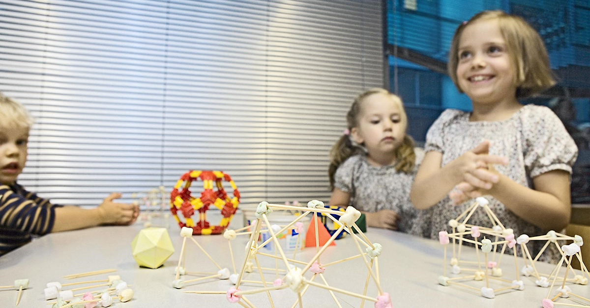 Kolme lasta rakentaa matemaattisia malleja hammastikuista ja vaahtokarkeista.