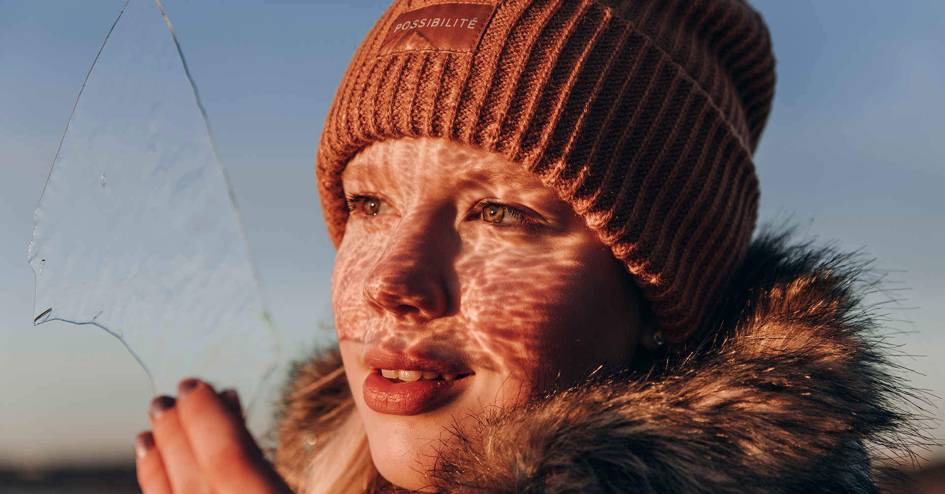 Kuvituskuva. Nuori tyttö pitää jääpalaa kädessään, josta heijastuu auringonsäteet. Kuva symbolisoi LUMA-yhteistyön kirkasta tulevaisuutta.